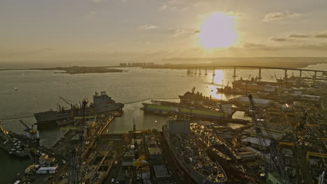 San-Diego-California-Aerial-v97-panning-view,-low-flyover-commercial-maritime-ship-building-sties-in-barrio-logan-industrial-area-with-bay-view-at-sunset---Shot-with-Mavic-3-Cine---September-2022