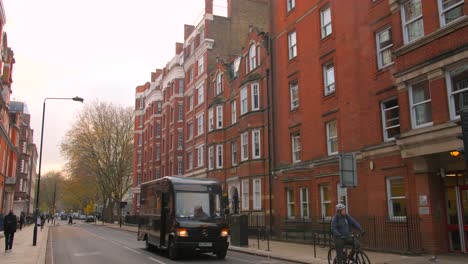 Viejos-Apartamentos-Tradicionales-Con-Arquitectura-De-Ladrillo-A-Lo-Largo-De-La-Calle-Típica-De-Londres,-Inglaterra-Durante-El-Día