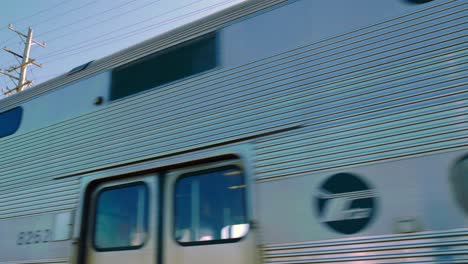 Metra-passenger-train-travels-high-speed-along-rail-road-through-the-city