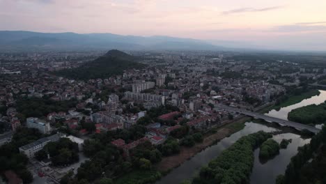 Establisher-shot-of-Plovdiv-cityscape-and-river-in-Bulgaria-at-dusk,-circle-pan