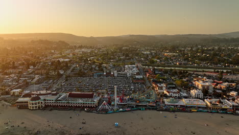 Santa-Cruz-California-Aerial-v12-panoramic-panning-view-flyover-beach-boardwalk-amusement-park-capturing-glowing-sun-shinning-across-townscape-and-san-lorenzo-river---Shot-with-Mavic-3-Cine---May-2022
