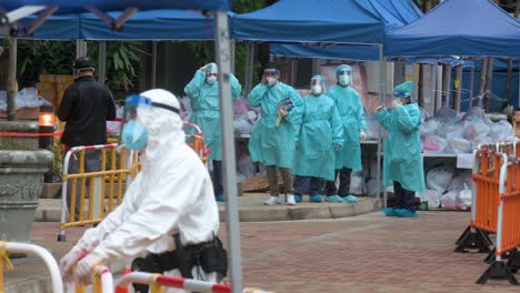 Health-workers-and-police-officers-wearing-PPE-suits-are-seen-standing-vigilant-outside-a-building-placed-under-lockdown-after-a-large-number-of-residents-tested-Covid-19-Coronavirus-positive
