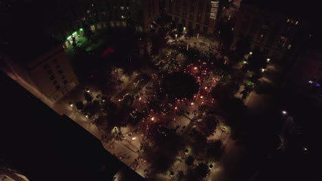 Aerial-view-of-square-at-night-time-with-people-enjoying-the-acrobat-event-in-Antigone,-Montpellier
