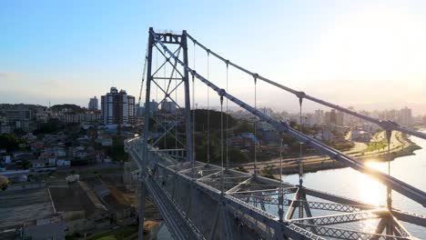 Luftaufnahme-Einer-Drohne,-Die-Tief-Und-Tief-über-Die-Schrägseilbrücke-Hercílio-Luz-In-Florianópolis-Fliegt,-Hauptstadt-Von-Santa-Catarina-Und-Stadtkulisse-Santa-Catarina-Postkarte