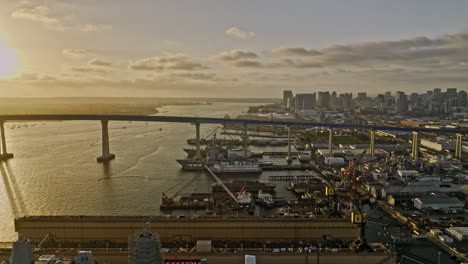 San-Diego-California-Aerial-v95-low-flyover-industrial-ship-building-sites-overlooking-at-coronado-bridge-and-downtown-cityscape-on-the-skyline-at-sunset---Shot-with-Mavic-3-Cine---September-2022