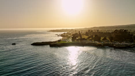 Santa-Cruz-California-Aerial-v2-fly-around-lighthouse-point-capturing-traffics-on-west-cliff-drive-and-golden-sunlight-reflecting-on-the-water-surface-at-sunset---Shot-with-Mavic-3-Cine---May-2022