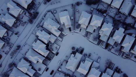 Top-down-drone-shot-of-the-community-covered-with-snow-in-winter-time