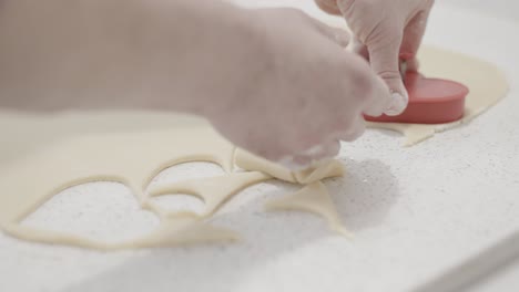 Cutting-out-heart-shaped-butter-cookies-in-a-pastry-shop-using-a-cookie-cutter,-4K