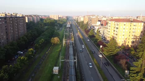 Passenger-metro-traveling-through-living-district-of-Milan,-aerial-view