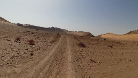Driving-in-a-desertic-valley-in-the-Moroccan-Sahara