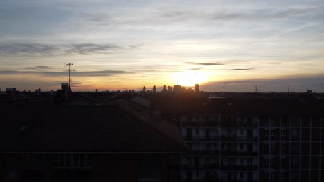 Revealing-Milano-city-skyline-during-golden-sunset,-ascend-above-buildings