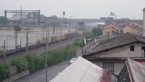 Colorful-cargo-train-in-suburbs-of-Milan,-view-from-above