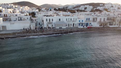 Astonishing-shot-of-approaching-the-picturesque-Naoussa-village-of-Paros-during-summer-sunset-in-Greece-from-the-sea-and-a-beach