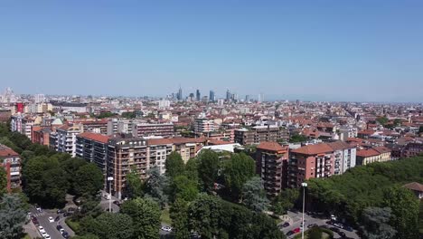 Apartment-buildings-and-Milan-city-skyline-in-distance,-aerial-fly-forward-view