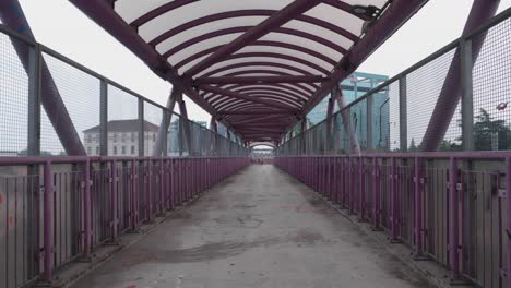 Moody-pedestrian-bridge-over-railway-in-Milan,-handheld-view