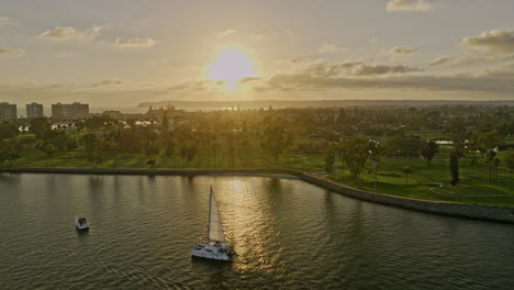 San-Diego-California-Aerial-v100-fly-along-bayfront-golf-course-in-coronado-resort-city-at-sunset-golden-hour-with-beautiful-sunlight-reflection-on-bay-water---Shot-with-Mavic-3-Cine---September-2022