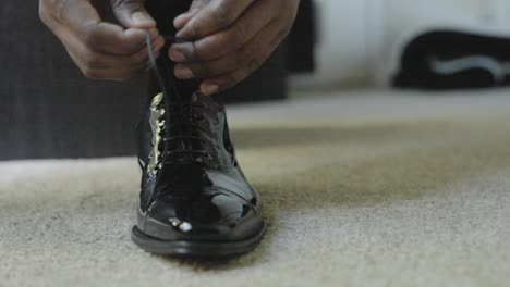 Close-up-shot-of-groom-tying-shoes-on-his-wedding-day