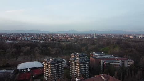 Foggy-mountains-and-skyline-of-Milan-city,-aerial-drone-view