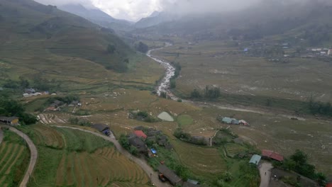 Stunning-drone-shot-of-the-fields-and-beautiful-cloudy-mountains-in-the-village-of-Sapa,-Vietnam