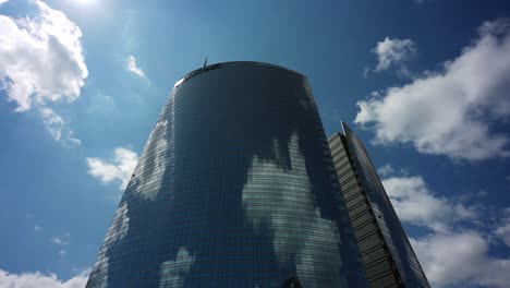 Sky-clouds-reflecting-on-Unicredit-Tower-of-Milan,-time-lapse-view
