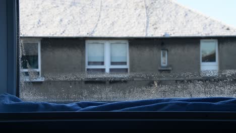 Breite-Aufnahme-Eines-Langen-Blauen-Handtuchs,-Das-Versucht,-Das-Kondenswasser-Vom-Fenster-Aufzusaugen