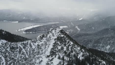 Aerial-establishing-shot-over-mountain-top-in-winter-time-with-hikers-on-top-on-a-cold-gray-day