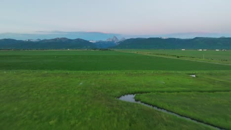 Aerial-View-Over-Vast-Green-Field-In-Driggs,-Idaho---drone-shot