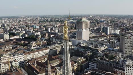 Milan-golden-symbol-on-top-of-Cathedral-rooftop,-aerial-orbit-view