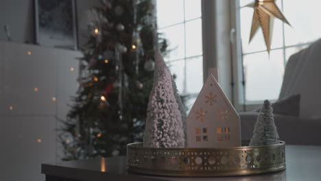 Christmas-ornament-on-table-with-decorated-tree-in-background