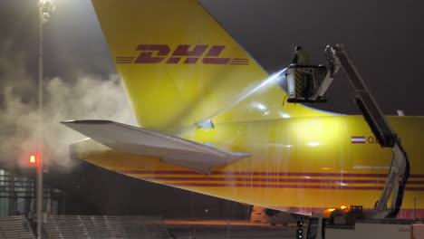 Tail-and-Elevator-of-DHL-Freighter-Airplane-Getting-De-icing-Treatment-during-a-Cold-Winter-Night