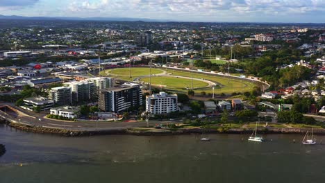Aerial-fly-around-capturing-Brisbane-city-metropolitan-racecourse,-Albion-park-paceway,-the-Creek-Harness-Racing-Club-located-next-to-breakfast-creek-at-sunset,-Queensland,-Australia