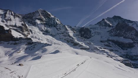 Aerial-shot-of-the-majestic-alpine-summits-Jungfrau-and-Monch---famous-top-of-Europe-on-snowy-winter