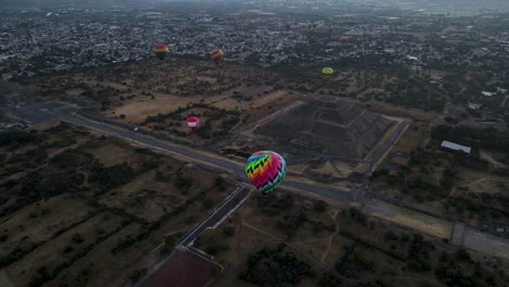 slow-motion-of-Gorgeous-view-of-Teotihuacan,-The-Sun-and-moon-Pyramid-surrounded-by-hot-air-balloons,-shooting-at-dusk