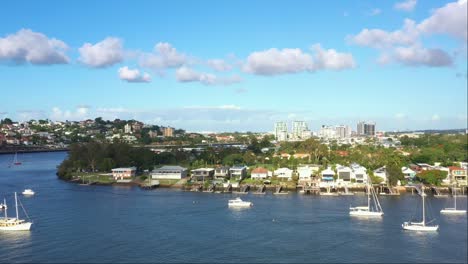 Aerial-elevation-shot-capturing-Brisbane-river-bend-and-riverfront-Bulimba-residential-neighborhood,-inner-city-suburb-on-a-sunny-day-with-beautiful-blue-sky,-Queensland,-Australia