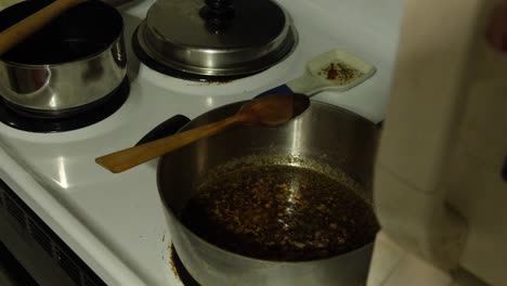 Time-lapse-of-a-bubbling,-boiling-pot-of-gross-green-brown-liquid-sludge-on-a-stove-top