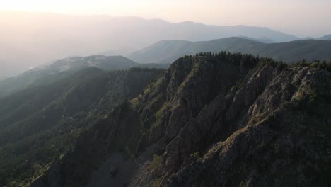 Bulgarian-mountain,-epic-aerial-drone-view-flying-along-high-peaks,-sunrise