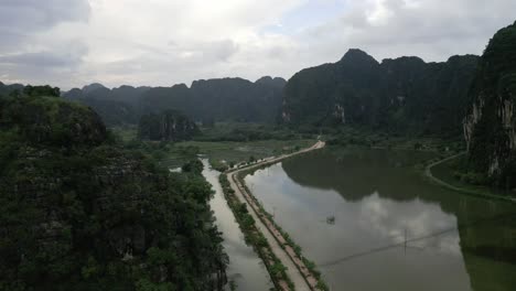 Schöne-Luftaufnahme-Einer-Einsamen-Straße-Inmitten-Von-Feuchtgebieten-In-Den-Bergen-Von-Nin-Bihn,-Vietnam