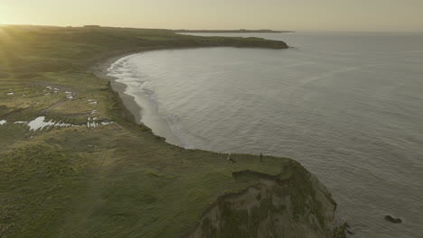 Scenic-coastline-with-Fortrose-cliffs-tourist-destination-during-sunrise,-aerial