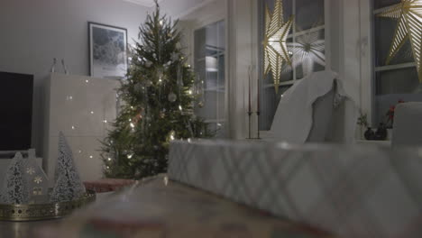 Closeup-of-Christmas-packed-gift,-rack-focus-slider-reveal-living-room-xmas-tree