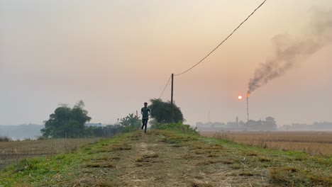 Low-angle-shot-of-man-jogging-towards-camera-in-hazy-morning-caused-by-gas-plant