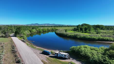 Lush-Vegetation-Reflecting-On-The-Calm-River-In-Saint-Anthony,-Idaho---aerial-drone-shot