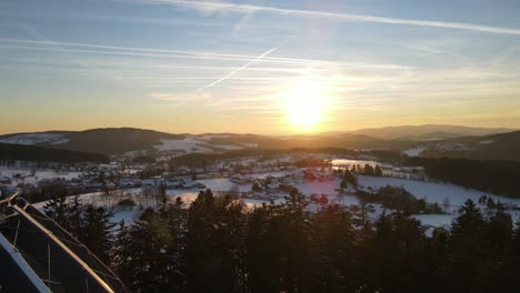 Aerial-establishing-shot-of-bavarian-forest-at-sunset-in-winter-and-snow