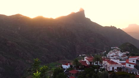 Majestic-Sunset-in-small-mountain-village-Tejeda-on-Gran-Canaria-with-sun-setting-behind-Roque-Bentayga-and-creating-beautiful-light-seen-from-above-with-view-of-white-houses-and-mountainside