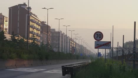 Speed-limit-and-end-of-Milan-city-sign-and-suburb-apartment-buildings-during-sunrise