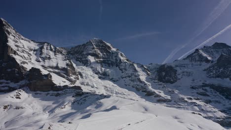 Majestic-alpine-summits-Jungfrau-and-Monch---an-aerial-panoramic-shot-of-the-famous-top-of-Europe-on-snowy-winter