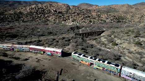 Vista-Aérea-Panorámica-Alta-Del-Desierto-De-California-Con-Vagones-De-Tren-Abandonados