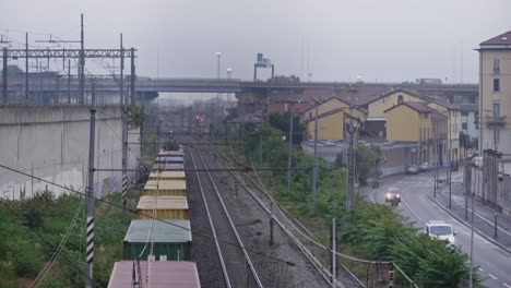 Tren-De-Carga-Tirando-De-Carros-En-Los-Suburbios-De-La-Ciudad-De-Milán,-Vista-De-Mano