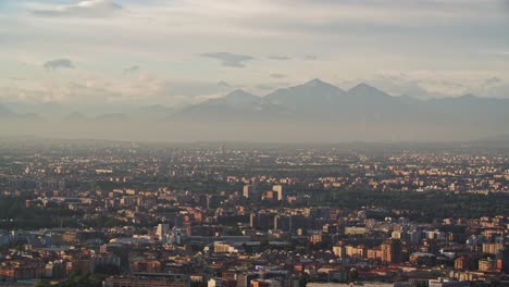 Aerial-view-of-Milan-cityscape,-Lombardy-and-mountains-in-horizon