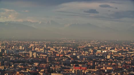 Foggy-mountain-range-and-Milan-cityscape,-view-from-above