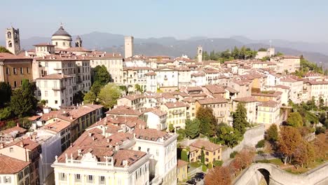 Bergamo-Citta-Alta-rooftops-on-sunny-day,-aerial-descend-view